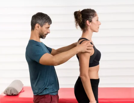 instrutor de pilates ajustando postura da aluna